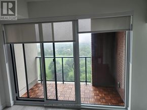 Toronto (Humber Heights) condo for rent - A balcony with a glass door leading to a view of trees.