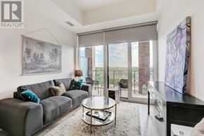 Mississauga (Port Credit) condo for rent - A living room with a grey couch and a glass coffee table.
