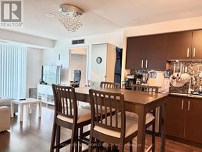 Toronto (Willowdale East) condo for rent - A well-lit kitchen with wooden chairs and a dining table.