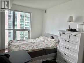 Toronto (Willowdale East) condo for rent - A bedroom with a large bed and a dresser with a lamp on top.