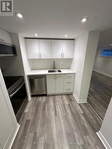 Richmond Hill (Mill Pond) apartment for rent - A kitchen with white cabinets and a wooden floor.