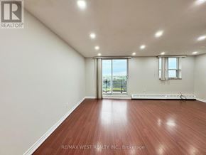 Mississauga (Malton) condo for rent - A room with a wooden floor and a sliding glass door leading to a balcony.