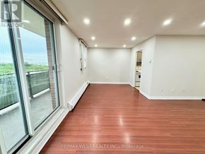 Mississauga (Malton) condo for rent - A spacious room with wood flooring and large windows.