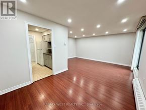 Mississauga (Malton) condo for rent - A room with wooden flooring and a doorway leading to another room.