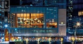 Toronto (Bay Street Corridor) condo for rent - A modern building with a glass facade and the words "Shangri-La Hotel" on it.