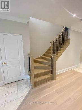 Markham (Greensborough) apartment for rent - A wooden staircase with a black railing in a white room.