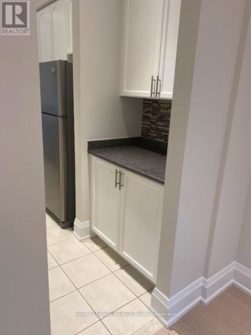 Markham (Greensborough) apartment for rent - A kitchen with white cabinets and a black fridge.