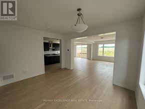 Kitchener apartment for rent - A spacious room with wooden flooring and a large window.