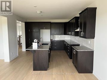 Kitchener apartment for rent - A kitchen with black cabinets and a wooden island.