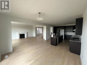 Kitchener apartment for rent - A spacious living room with a fireplace and a kitchen area with black cabinets.