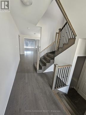 North Dumfries apartment for rent - A hallway with a staircase and a doorway in the distance.