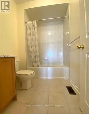 Richmond Hill townhouse for rent - A white bathroom with a toilet, a shower curtain, and a door.
