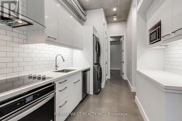 Toronto (Keelesdale-Eglinton West) multi-family for rent - A modern kitchen with white cabinets and stainless steel appliances.