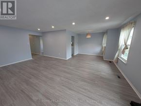 Toronto (Tam O'shanter-Sullivan) apartment for rent - A spacious room with wooden flooring and a large window with curtains.
