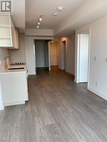 Toronto (Niagara) condo for rent - A kitchen with white cabinets and a white stove top oven.