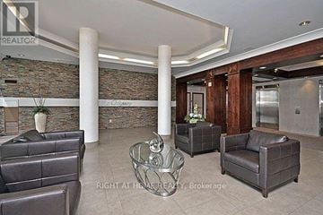 Mississauga (City Centre) condo for rent - A living room with a stone wall and leather furniture.