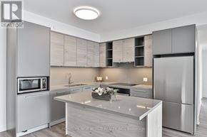 Markham (Commerce Valley) condo for rent - A modern kitchen with a large island in the middle.