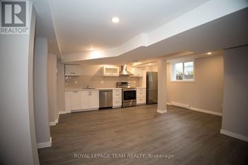 Ottawa apartment for rent - A spacious kitchen with white cabinets and stainless steel appliances.