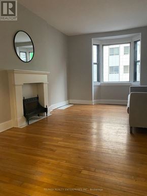 Hamilton (Durand) apartment for rent - A living room with a grey couch and a television on the wall.