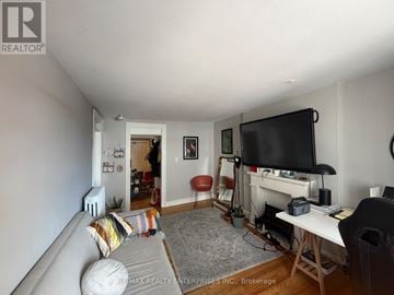 Hamilton (Durand) apartment for rent - A living room with a grey couch and a television on the wall.