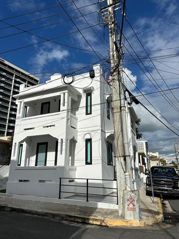 San Juan apartment for rent - A white building with a black truck parked in front of it.
