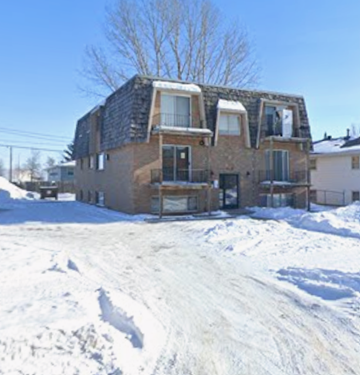 Moorhead apartment for rent - A house with a grey roof and a balcony covered in snow.