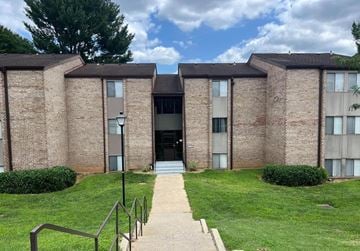 Montgomery Village apartment for rent - A building with a brick facade and a green lawn in front.