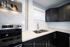 Cambridge apartment for rent - A modern kitchen with a stove, sink, and cabinets.