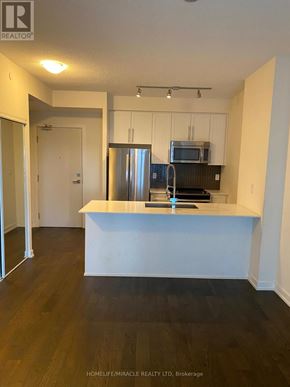 Mississauga (City Centre) condo for rent - A kitchen with a refrigerator, microwave, and oven.