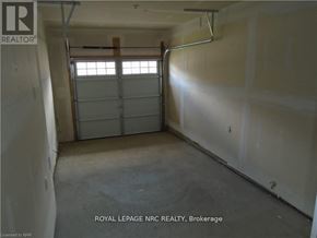 Thorold (Rolling Meadows) townhouse for rent - A large empty room with a window and a door in the middle.