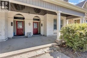 Brantford apartment for rent - A white house with a red door and a sign that says REALTOR.