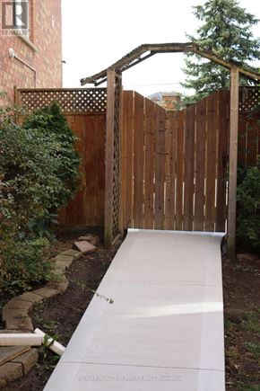 Brampton (Northwest Sandalwood Parkway) apartment for rent - A wooden fence with a gate and a concrete pathway leading to it.