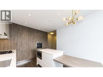 Burnaby apartment for rent - A modern kitchen with a wooden cabinet and a white countertop.