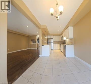 Hamilton townhouse for rent - A spacious kitchen with white cabinets and a central island.