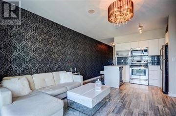 Toronto (Niagara) condo for rent - A modern living room with a white sofa and a patterned wallpaper.