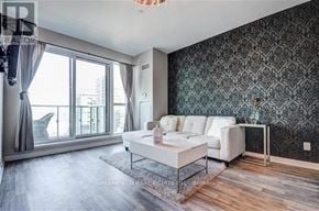 Toronto (Niagara) condo for rent - A living room with a white couch and a glass table.