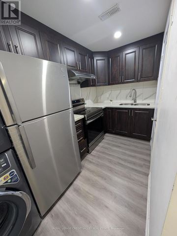 Brampton (Bram East) apartment for rent - A kitchen with a stainless steel refrigerator and wooden cabinets.
