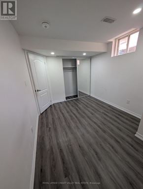 Brampton (Bram East) apartment for rent - A room with a wooden floor and white walls.