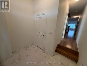 Whitby townhouse for rent - A hallway with a white door and a wooden staircase.