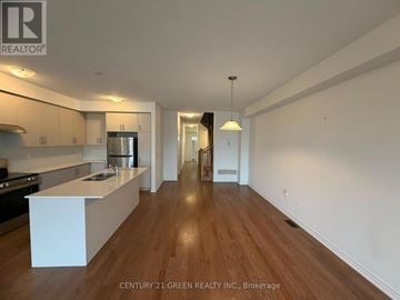 Whitby townhouse for rent - A well-lit, spacious kitchen and living room with wooden floors and white walls.