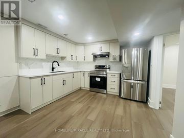 Ajax (Central) apartment for rent - A kitchen with white cabinets and a wooden floor.