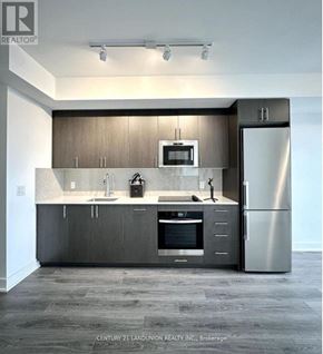 Oshawa (Windfields) condo for rent - A modern kitchen with stainless steel appliances and wooden cabinets.