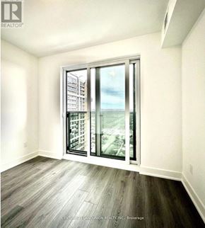 Oshawa (Windfields) condo for rent - A room with a view of a cityscape through a large window.