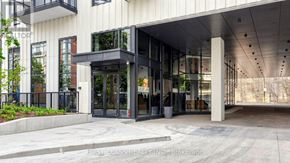 Toronto (Forest Hill South) condo for rent - The entrance to a building with a glass door and a black railing.