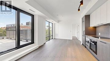 Toronto (Forest Hill South) condo for rent - A modern kitchen with white cabinets and a wooden floor.