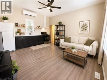 Brantford apartment for rent - A living room with a white couch and a wooden floor.