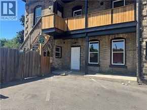 Brantford apartment for rent - A building with a wooden fence in front of it.