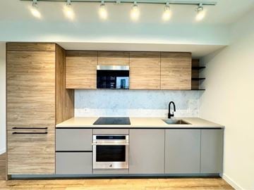 Surrey apartment for rent - A modern kitchen with a wooden cabinet and a stainless steel oven.