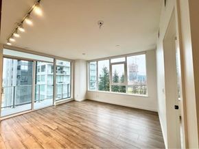 Surrey apartment for rent - A spacious room with wooden flooring and large windows overlooking a cityscape.
