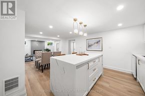 Newmarket (Central Newmarket) apartment for rent - A well-lit, spacious kitchen with white cabinets and a dining area with a table set for four.